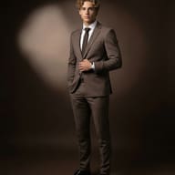 Man in Brown Suit Formal Portrait AI Photo Editing Prompt. AI generated studio portrait of a young man with curly blonde hair wearing a tailored brown suit, white shirt, and dark tie.