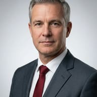 AI generated studio portrait of a middle-aged man with salt-and-pepper hair wearing a charcoal grey suit and a burgundy red tie.