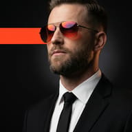 Man in Suit with Tinted Aviators AI Photo Editing Prompt. AI generated studio portrait of a bearded man in a black suit and tie wearing orange-tinted sunglasses with a cinematic light streak.