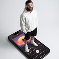 AI generated conceptual digital illustration of a man in a white hoodie and headphones standing on a massive smartphone screen displaying a music player interface.
