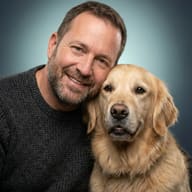 Man and Golden Retriever AI Photo Editing Prompt. AI generated studio portrait of a smiling man in a grey knitted sweater with his head leaning against a Golden Retriever dog.